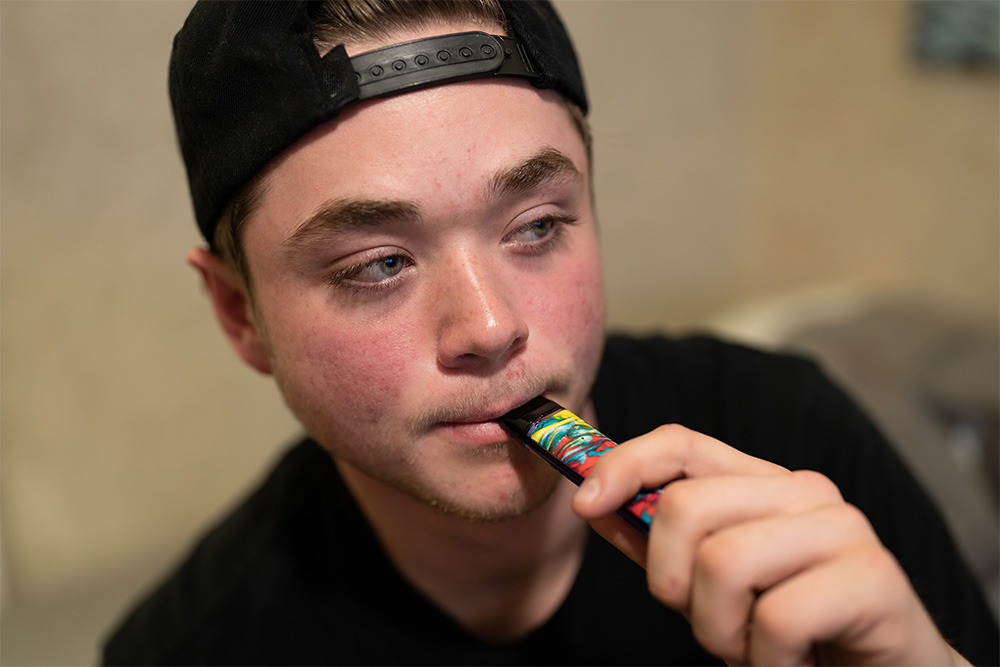 a teenager vaping indoors